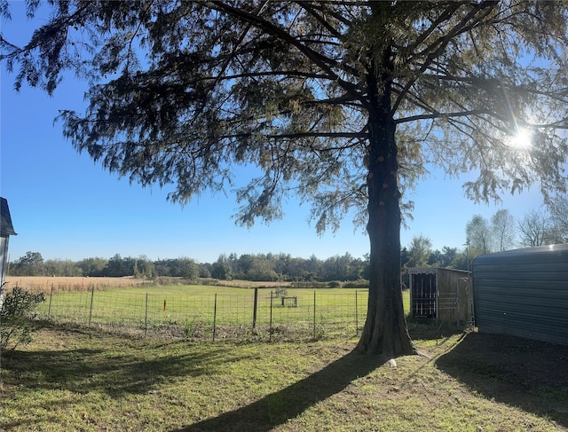 view of yard featuring a rural view and an outdoor structure