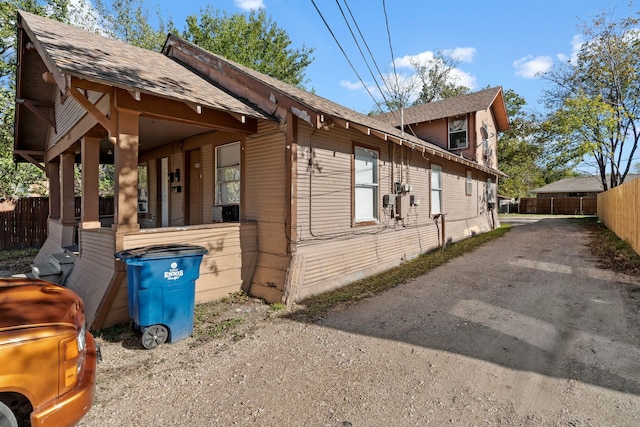 view of side of property featuring a porch and cooling unit