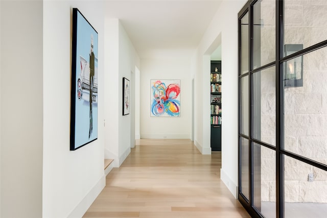 corridor featuring light hardwood / wood-style floors and a wealth of natural light