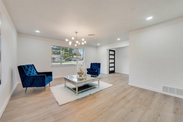 living area featuring light hardwood / wood-style flooring, a chandelier, and ornamental molding