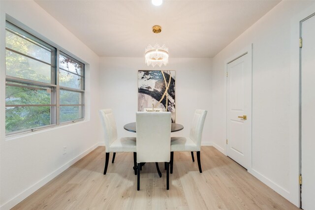 dining room with a chandelier and light wood-type flooring