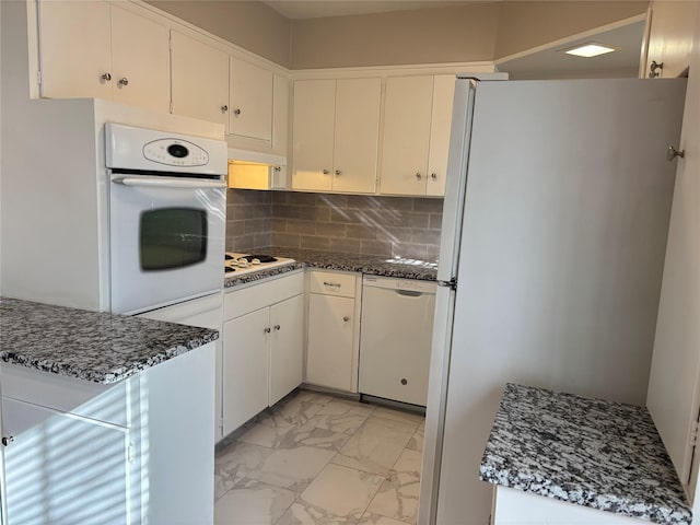 kitchen featuring white cabinets, decorative backsplash, and white appliances