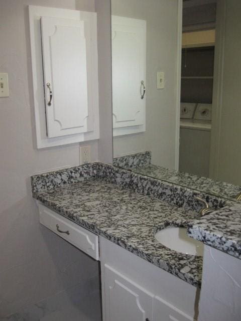 bathroom featuring washer / clothes dryer and vanity