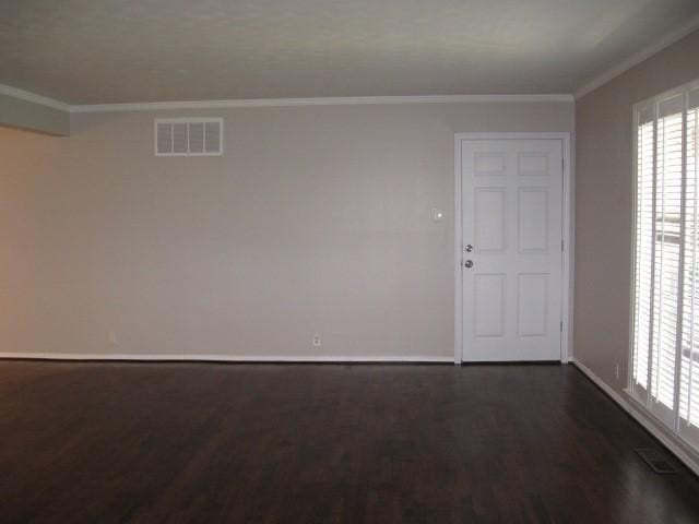 spare room featuring crown molding and dark wood-type flooring