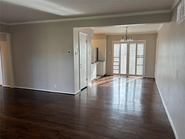 spare room featuring dark hardwood / wood-style flooring, a chandelier, and ornamental molding