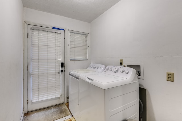 clothes washing area featuring independent washer and dryer and a textured ceiling