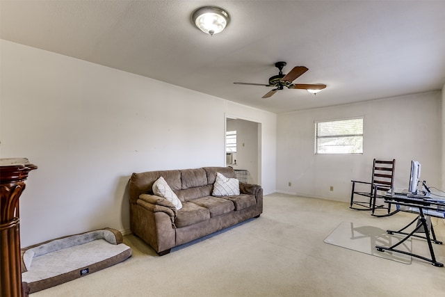 carpeted living room with ceiling fan