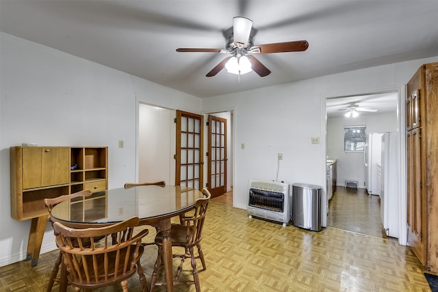 dining room with heating unit, light parquet floors, and ceiling fan