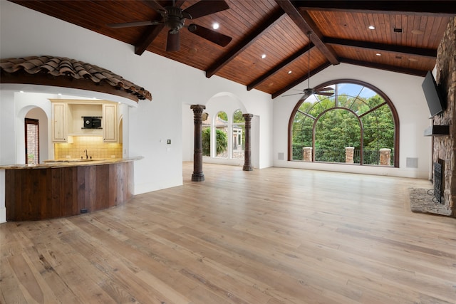 unfurnished living room featuring high vaulted ceiling, light hardwood / wood-style flooring, a stone fireplace, and wood ceiling