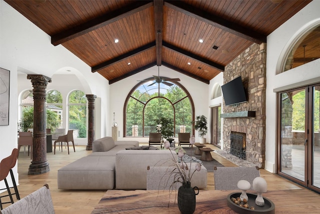 living area featuring high vaulted ceiling, a wealth of natural light, light wood-style flooring, and ornate columns