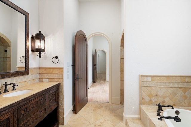 bathroom with tile patterned floors, a tub, and vanity