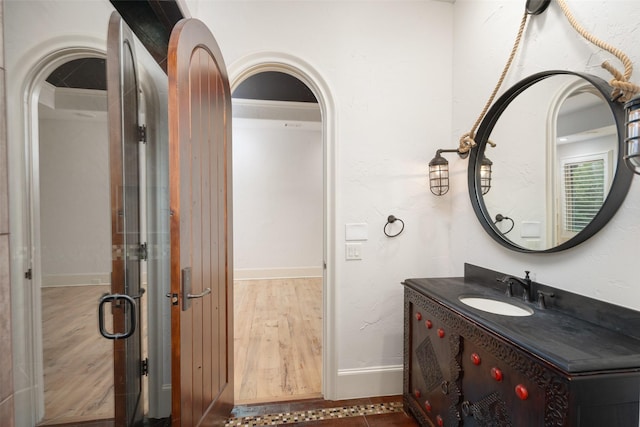 bathroom with vanity, baseboards, and wood finished floors