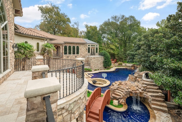 view of pool with pool water feature and a patio area