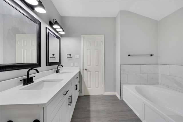 2631 Leisure Ln, Little Elm, TX 75068 - full bathroom featuring double vanity, a bath, wood finished floors, and baseboards