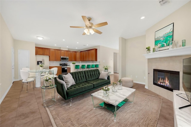 tiled living room featuring a tile fireplace and ceiling fan