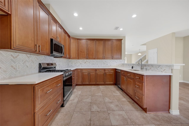 kitchen featuring appliances with stainless steel finishes, tasteful backsplash, sink, light tile patterned floors, and kitchen peninsula