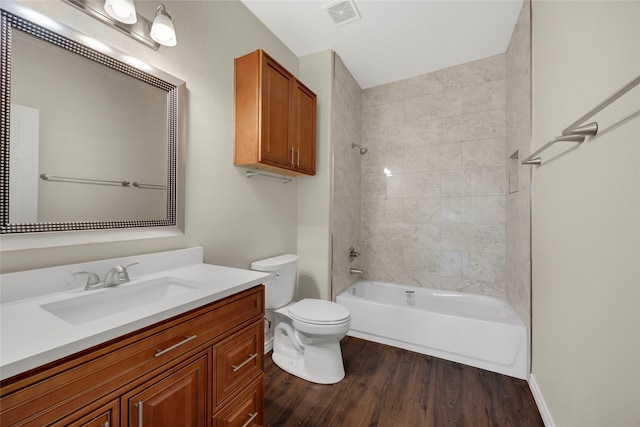 full bathroom featuring vanity, hardwood / wood-style flooring, toilet, and tiled shower / bath