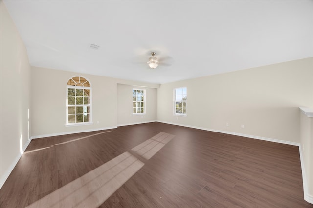 empty room with dark hardwood / wood-style floors and ceiling fan