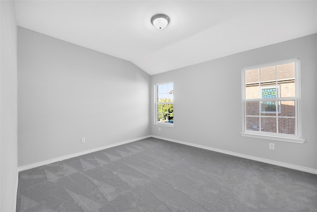 carpeted spare room featuring lofted ceiling