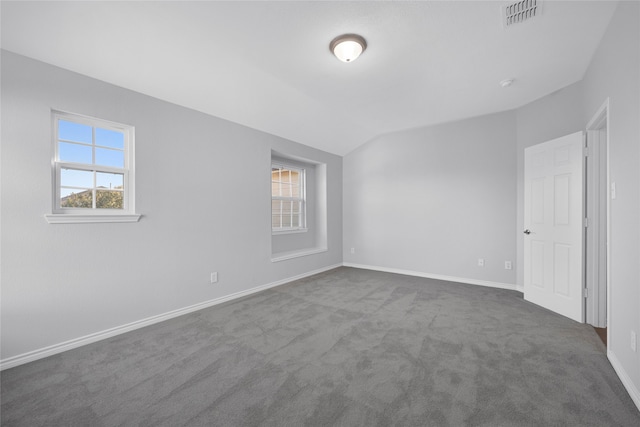 carpeted empty room with vaulted ceiling and plenty of natural light