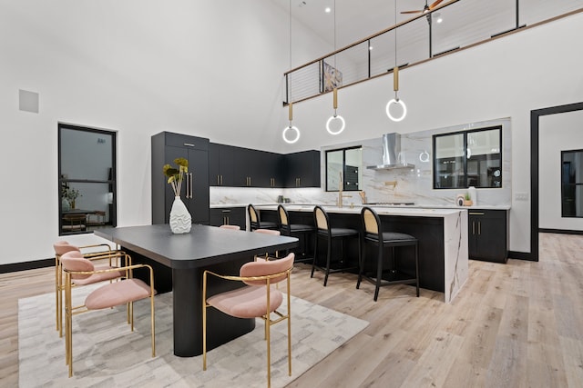 dining space with high vaulted ceiling and light wood-type flooring