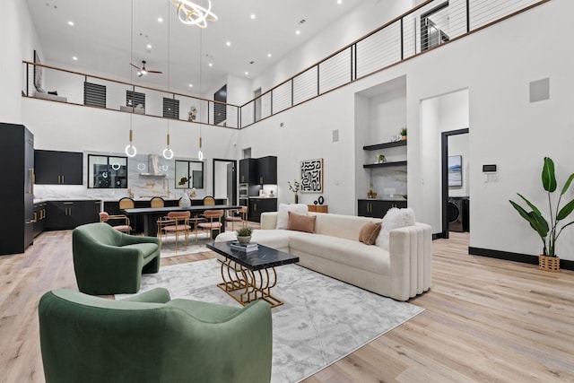 living room featuring a high ceiling and light hardwood / wood-style floors