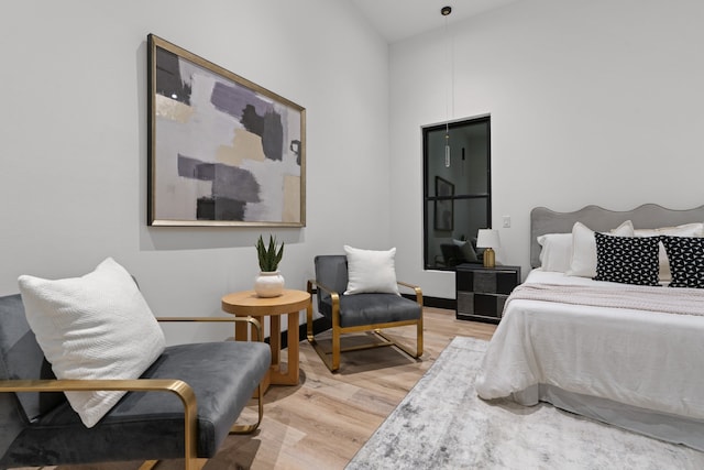 bedroom featuring light hardwood / wood-style floors and high vaulted ceiling