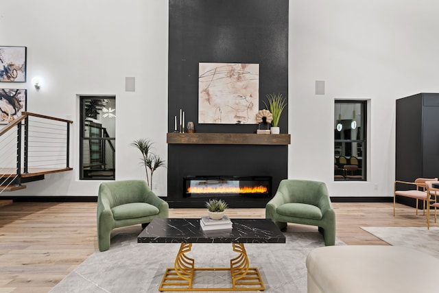 living room featuring light hardwood / wood-style floors and a towering ceiling