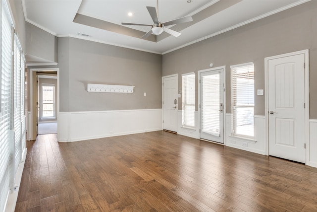 unfurnished room with ceiling fan, dark hardwood / wood-style flooring, ornamental molding, and a tray ceiling