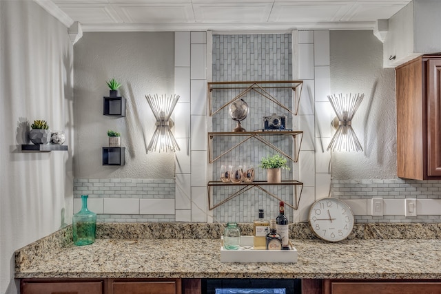 kitchen with tasteful backsplash, light stone counters, and crown molding