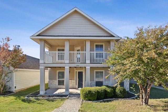 view of front facade with a porch, a balcony, and a front lawn