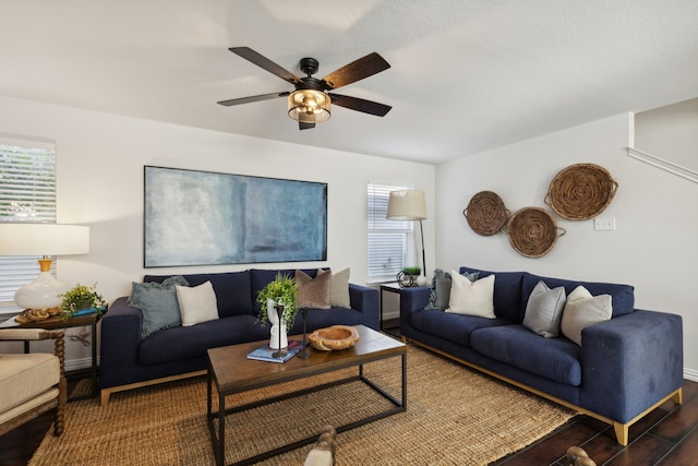 living room featuring ceiling fan and dark wood-type flooring