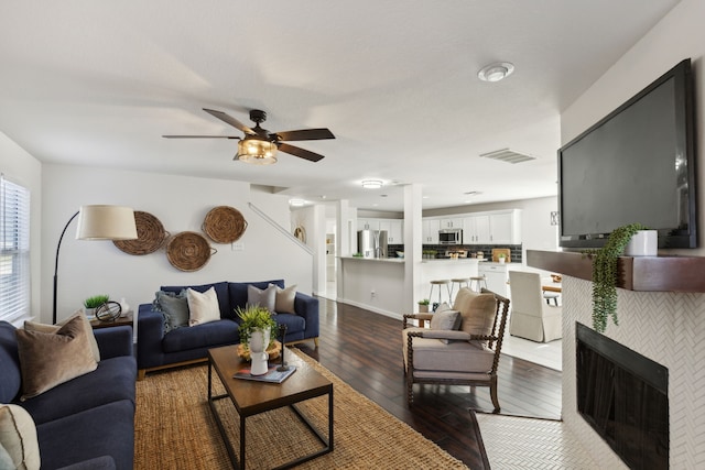 living room with a tile fireplace, ceiling fan, and hardwood / wood-style flooring