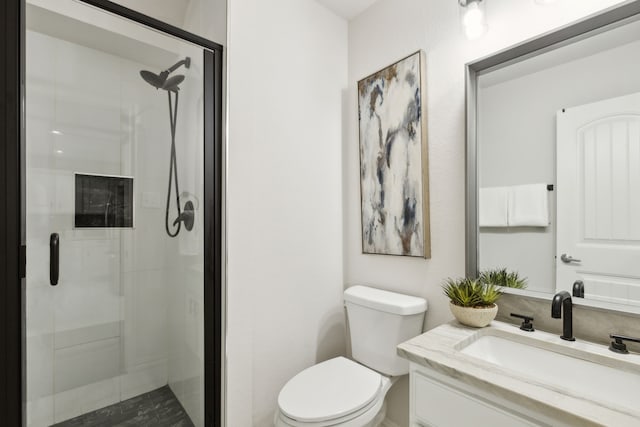 bathroom with an enclosed shower, vanity, and toilet