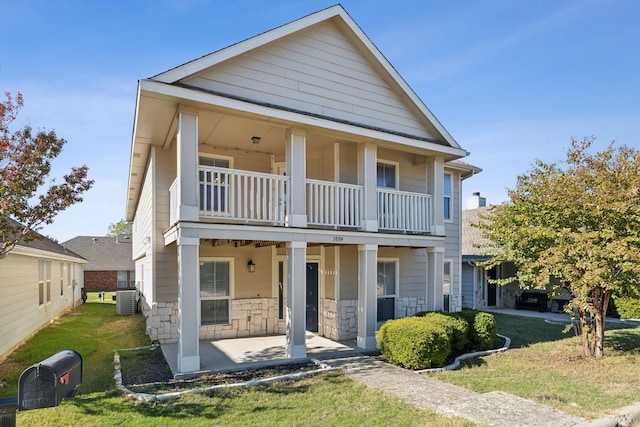 view of front facade featuring central AC, a balcony, and a front lawn