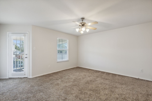 carpeted spare room featuring ceiling fan and a healthy amount of sunlight