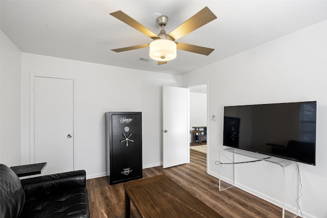 living room featuring ceiling fan and dark hardwood / wood-style floors