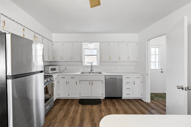 kitchen with dark hardwood / wood-style flooring, white cabinetry, sink, and stainless steel appliances