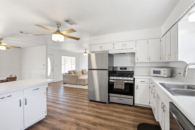 kitchen featuring white cabinets, appliances with stainless steel finishes, dark wood-type flooring, and sink