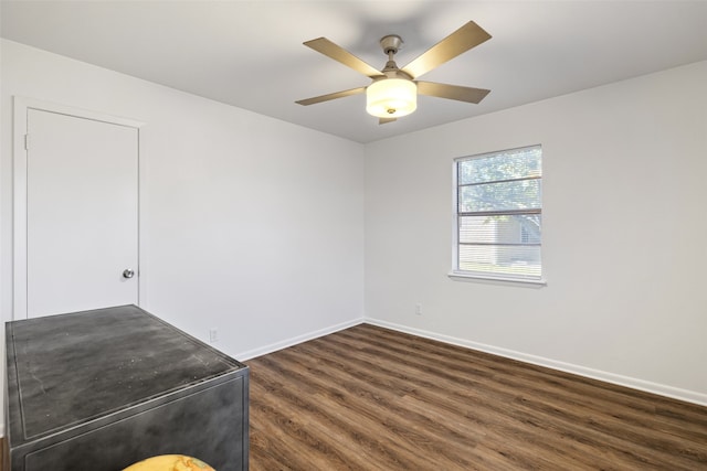 spare room featuring ceiling fan and dark wood-type flooring