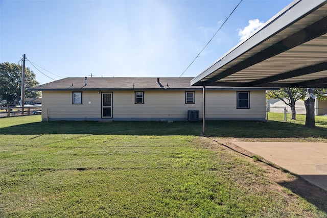 back of house with a lawn, cooling unit, and a carport