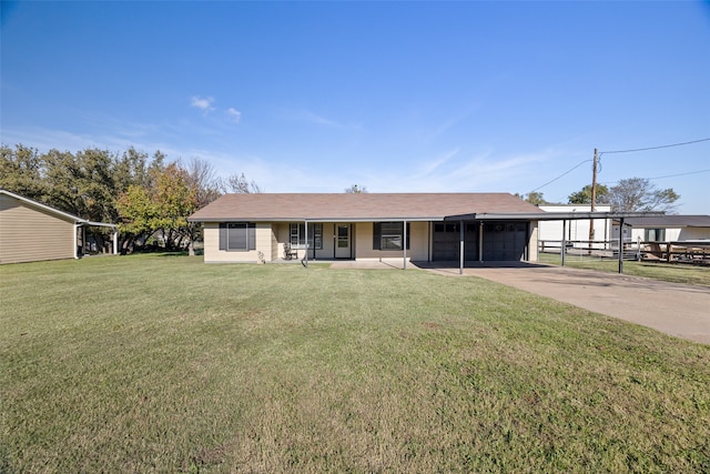 ranch-style home featuring covered porch, a carport, and a front yard