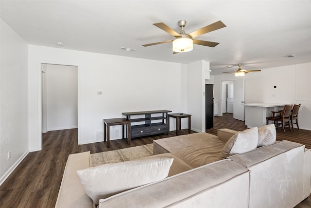 living room featuring ceiling fan and dark wood-type flooring