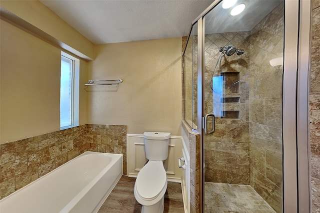 bathroom with toilet, wood-type flooring, a textured ceiling, and independent shower and bath