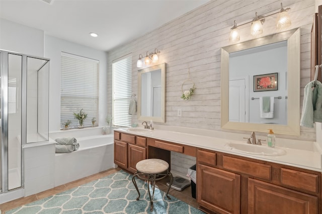 bathroom with tile patterned flooring, vanity, and plus walk in shower