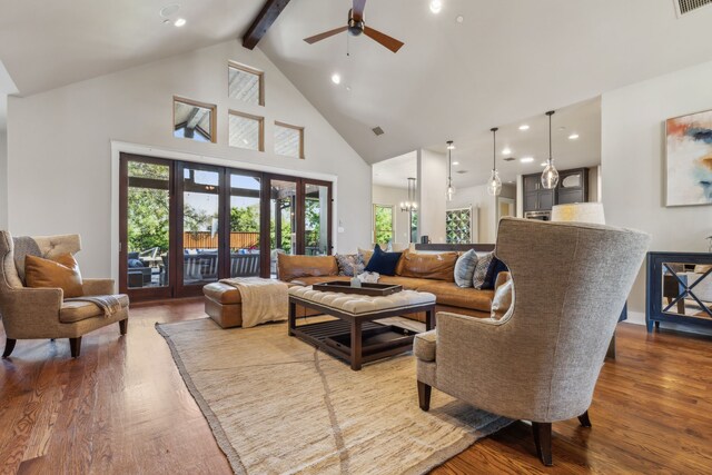 living room with ceiling fan with notable chandelier, beam ceiling, wood-type flooring, and high vaulted ceiling