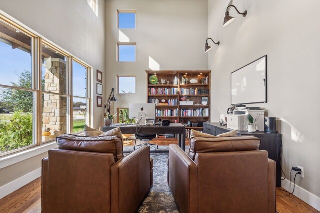 living room featuring wood-type flooring and a high ceiling