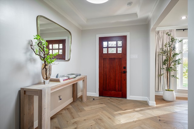 foyer entrance with a tray ceiling, plenty of natural light, and crown molding