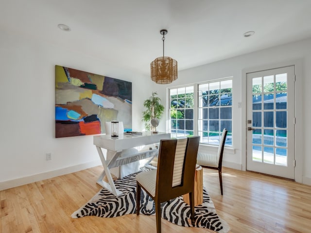 dining space featuring a chandelier, a healthy amount of sunlight, and light hardwood / wood-style floors