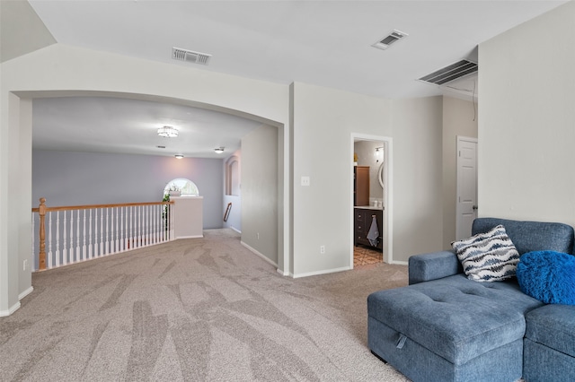 sitting room featuring lofted ceiling and light colored carpet